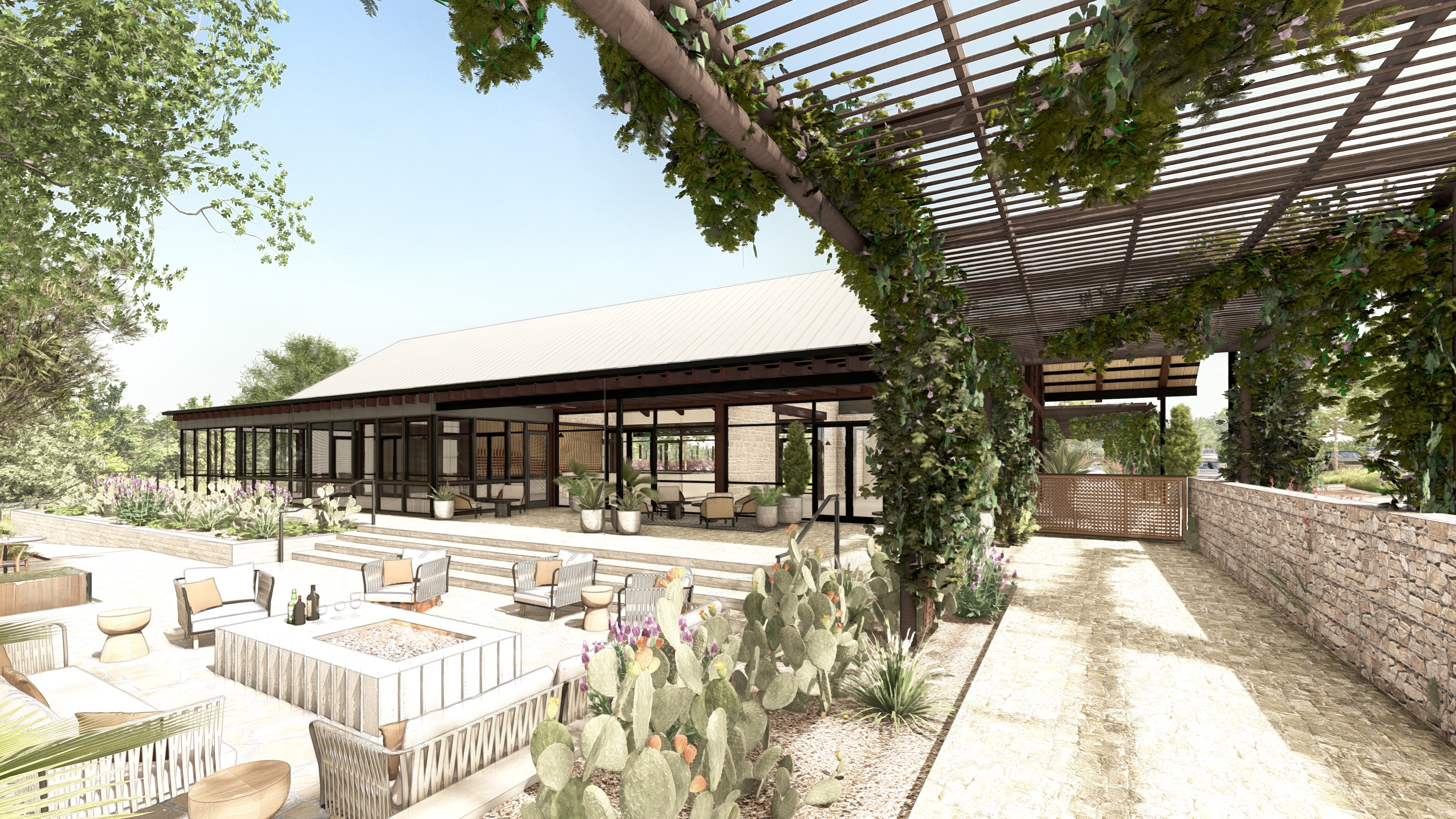 Outdoor patio area with seating, fire pit, and greenery beside a modern building with large windows and a pergola covered in vines.